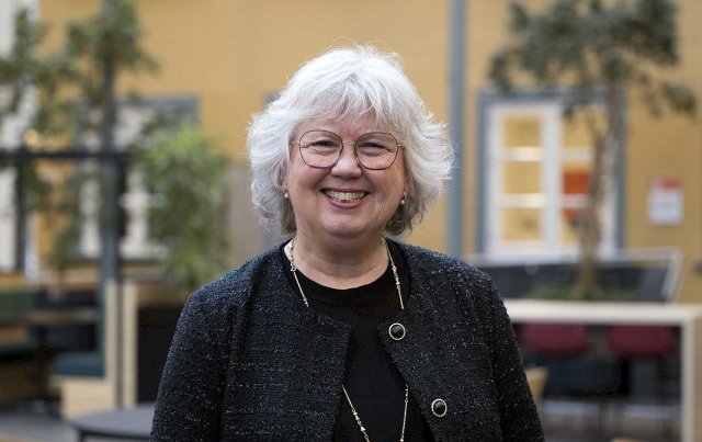 Vosken dame ser i kamera og smiler