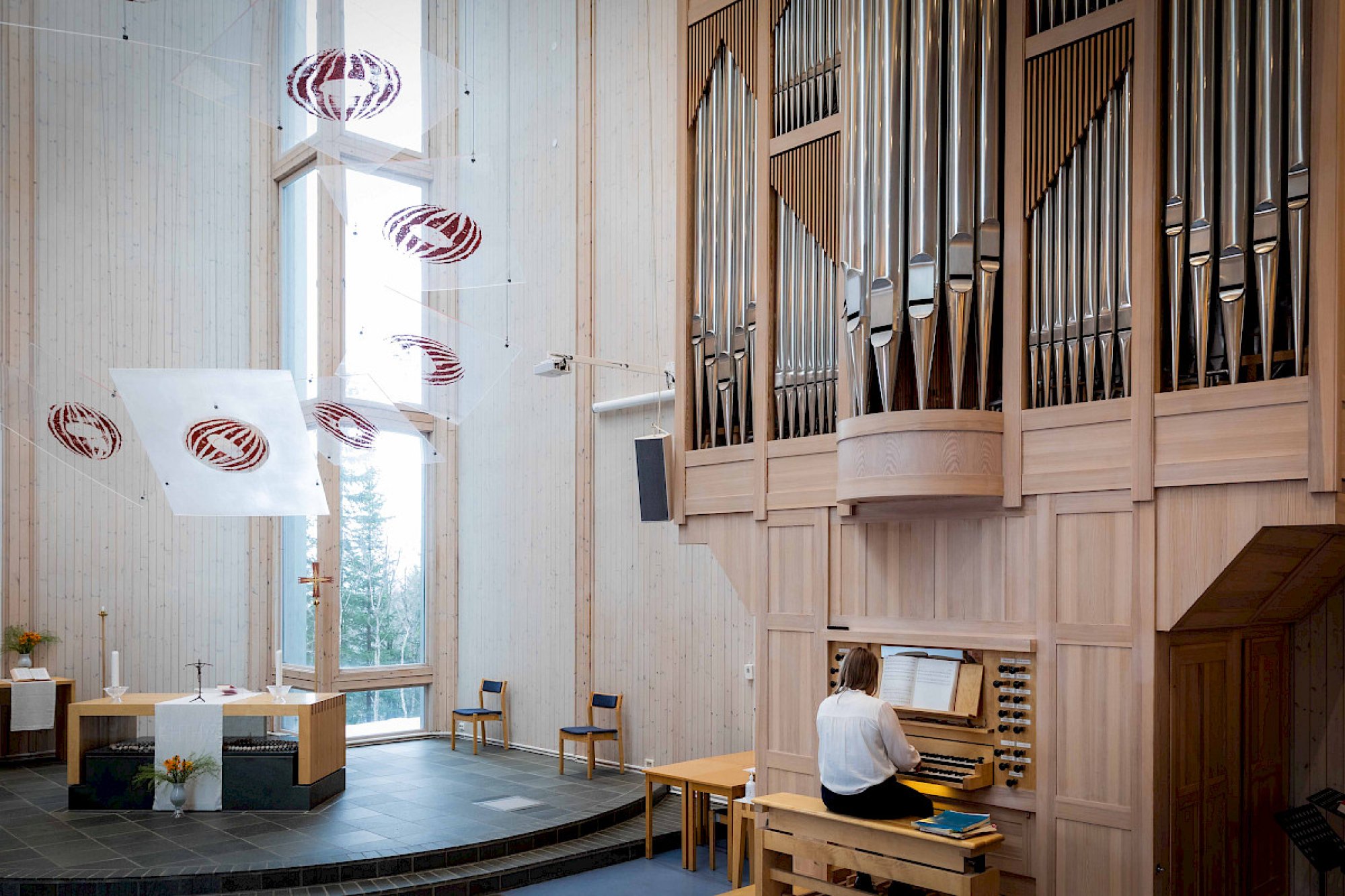 En organist sitter foran et kirkeorgel i et kirkerom