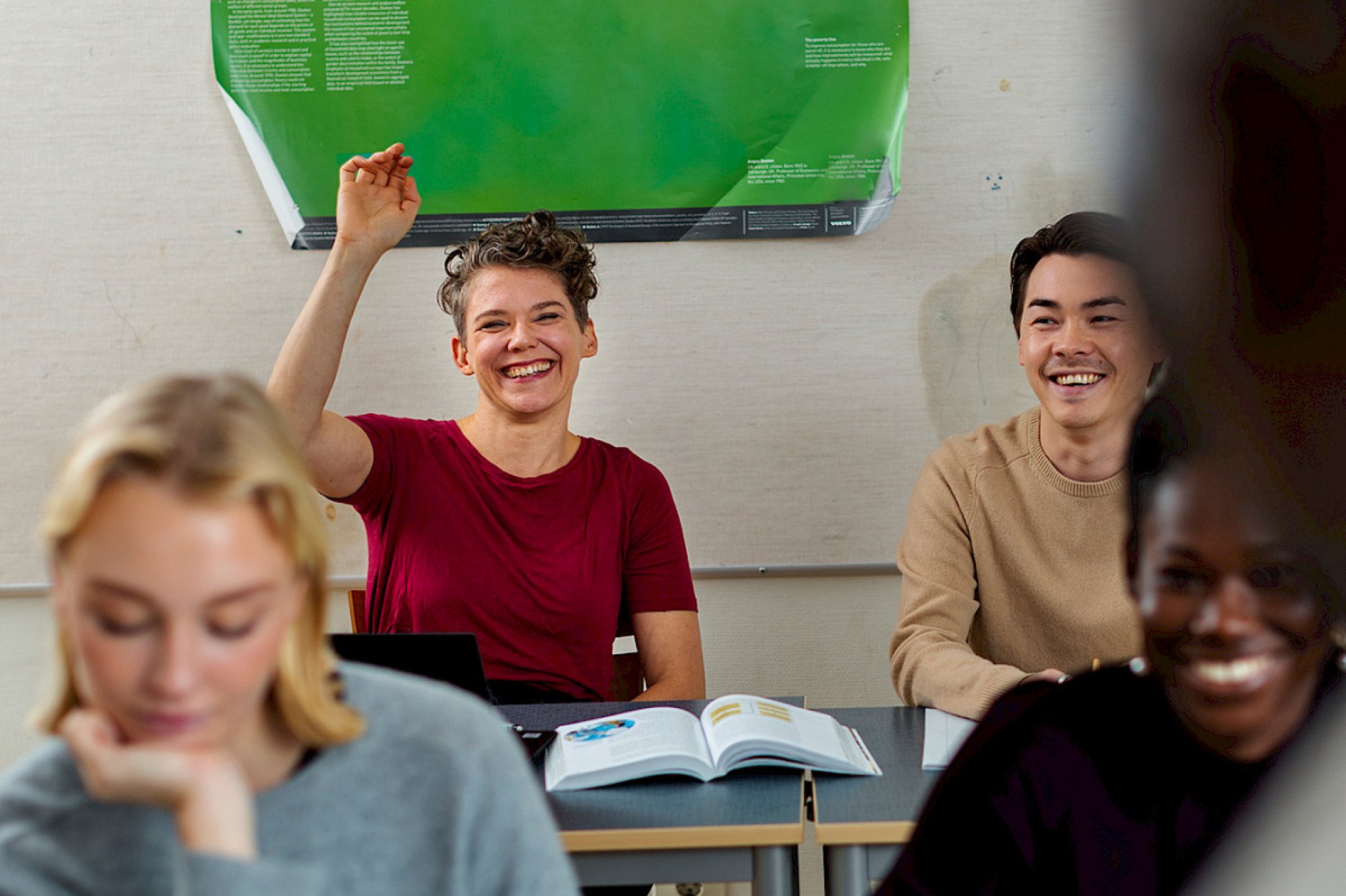 En student rekker opp hånden i et klasserom