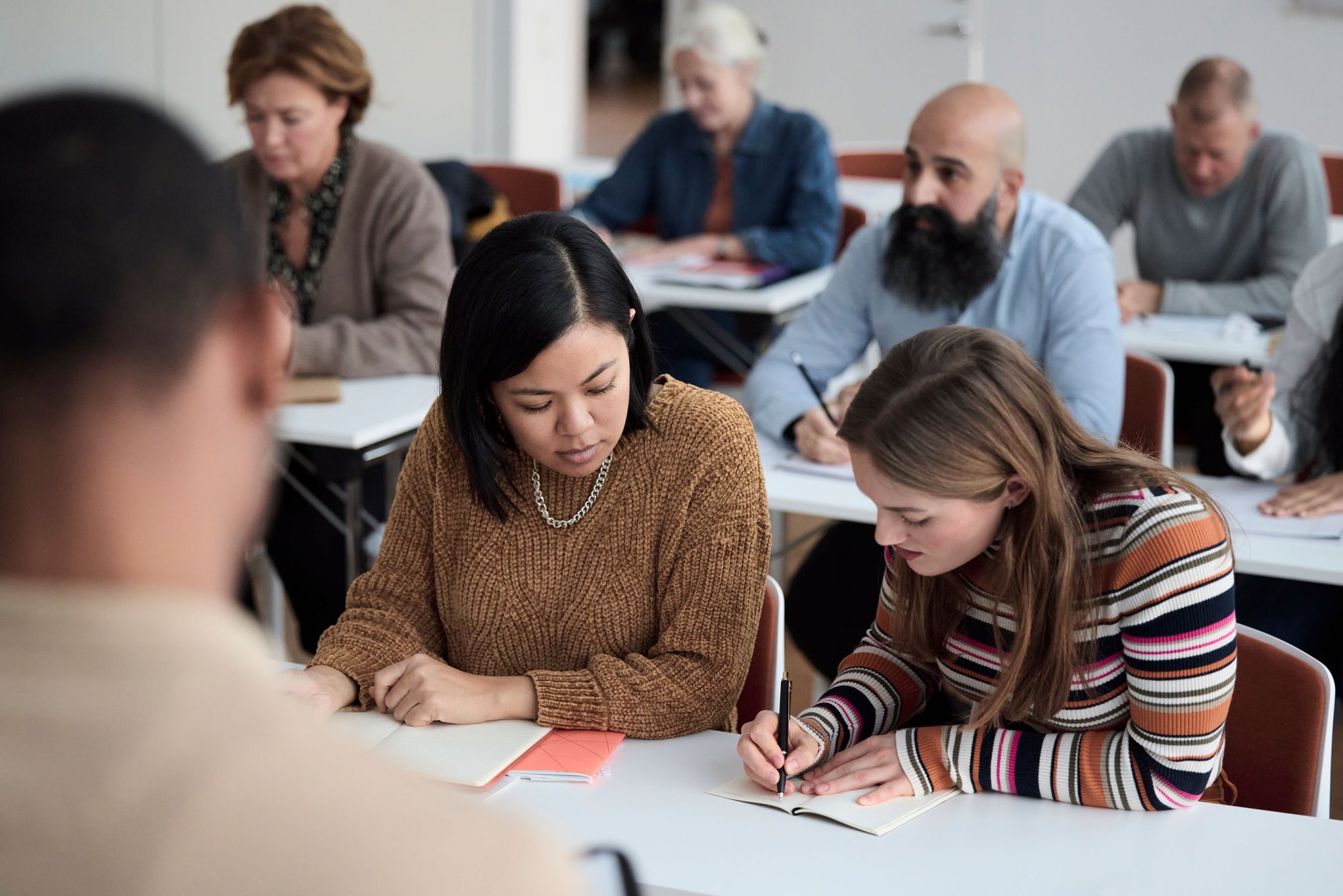 Studenter sitter og jobber i et klasserom