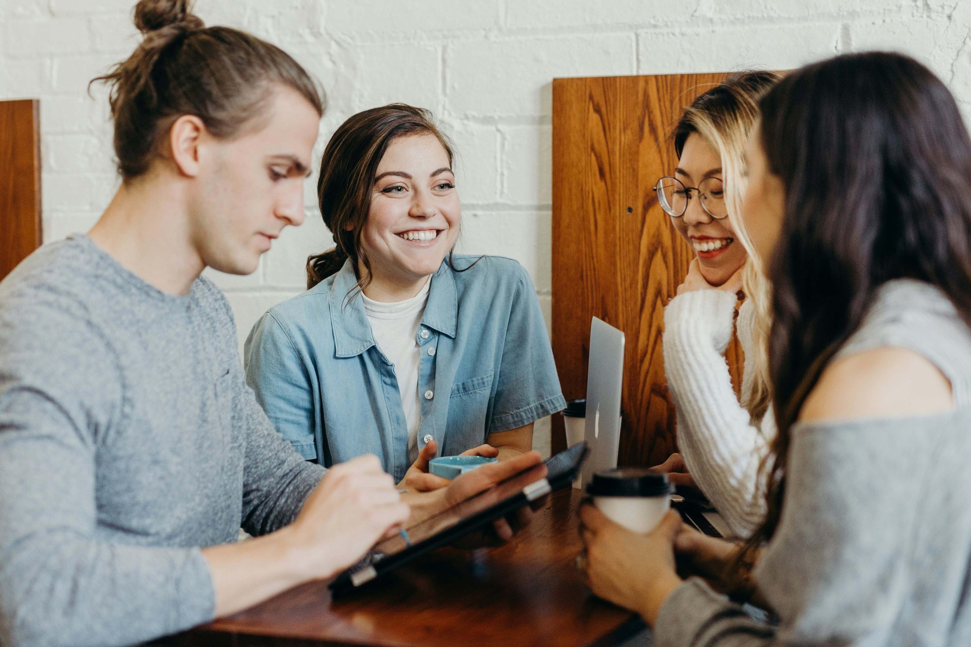 Fire glade studenter sitter rundt et bord